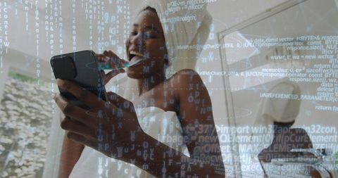 Brushing teeth while holding smartphone and checking mirror with digital code overlay
