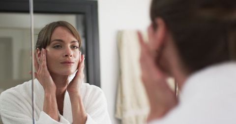 Middle-aged Woman Practicing Skincare Routine in Bathroom - Download Free Stock Images Pikwizard.com