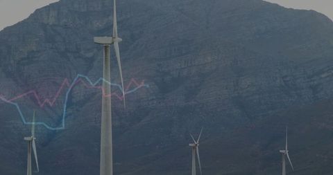 Wind turbine dominating mountain ridge with translucent blue-pink energy graph overlay