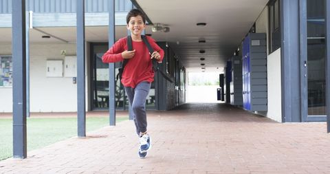 Happy Young Student Running Through School Corridor with Backpack - Download Free Stock Images Pikwizard.com