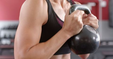 Focused Woman Holding Kettlebell for Strength Training