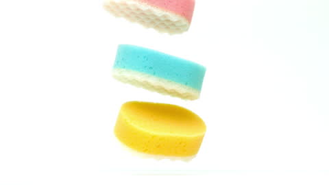 Assorted Colored Sponges Floating on White Background