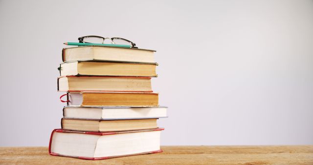 Tall Stack of Colorful Books with Glasses on Wooden Table - Download Free Stock Images Pikwizard.com