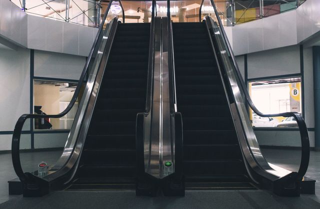 This image can be used to depict modern infrastructure in shopping malls or commercial spaces. Ideal for websites or brochures focusing on retail spaces, transportation systems, and urban architectural designs. Use it to illustrate articles about mall dynamics, foot traffic patterns, or innovative architectural trends.