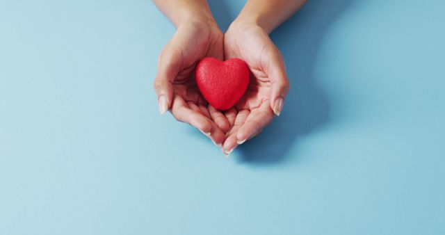 Image of hands of caucasian woman holding heart on blue background - Download Free Stock Photos Pikwizard.com