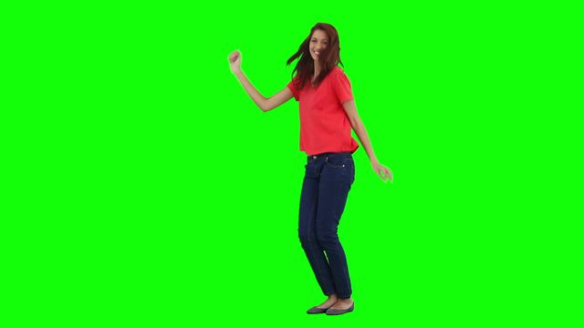 Joyful woman dancing alone in casual clothes against a green screen background. Suitable for promotional materials, video overlays, advertisements, and entertainment content. Perfect for creative projects requiring dynamic and fun imagery.