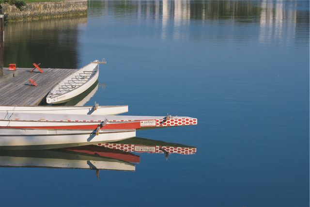Calm Waterfront with Canoes Reflected in Still Water - Download Free Stock Photos Pikwizard.com