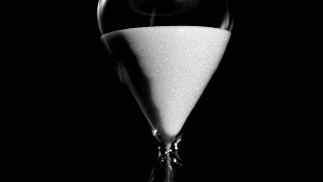 Hourglass with sand falling slowly, symbolizing time passing and urgency. Perfect for illustrating concepts of time management, deadlines, and punctuality in business or personal projects. Can be used in advertisements, educational materials, or presentations.