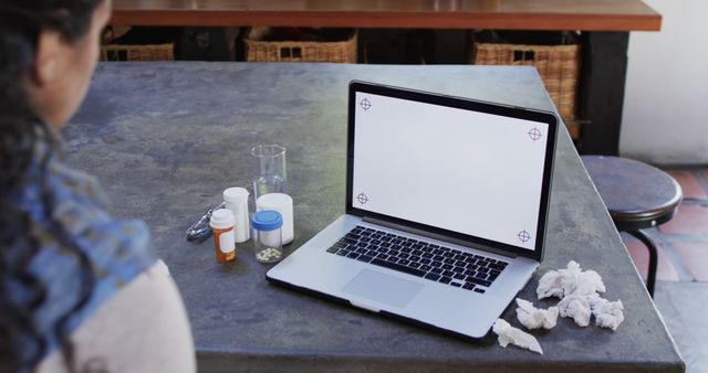 Person at table with laptop and medical supplies - Download Free Stock Images Pikwizard.com