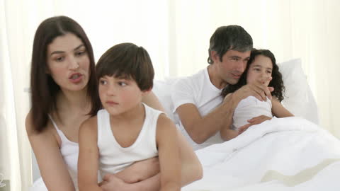 Happy Family Relaxing on White Bedding