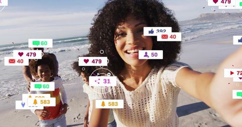Smiling woman taking family beach selfie with floating social media notifications and likes