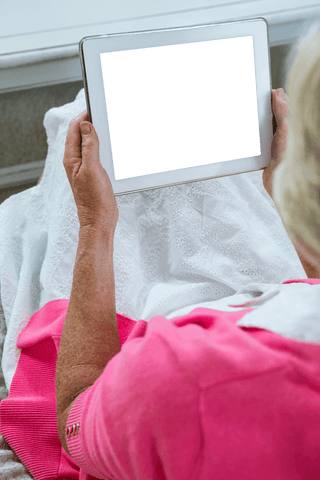 elderly woman holding transparent tablet in cozy home setting - Download Free Stock Videos Pikwizard.com