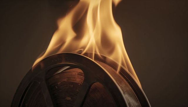 Dramatic Flames Engulfing Spinning Film Reel in Studio Setting