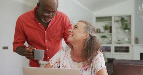 Happy Senior Couple Using Laptop in Living Room