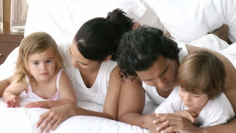 Happy Multicultural Family Enjoying Morning in Bed