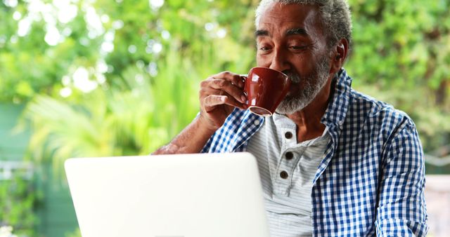 Elderly Man Drinking Coffee While Using Laptop Outside in Green Garden - Download Free Stock Images Pikwizard.com