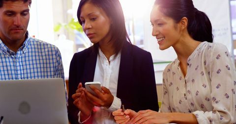 Diverse Business Team Collaborating on Laptop in Office