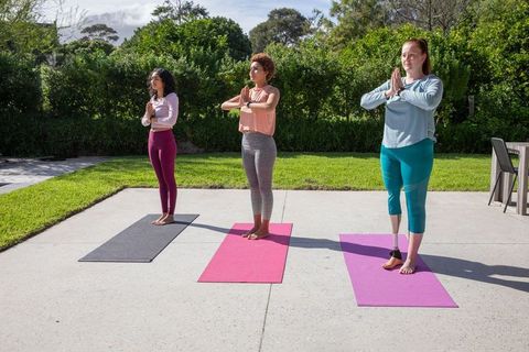 Group of Women Practicing Yoga Outdoors on Colorful Mats