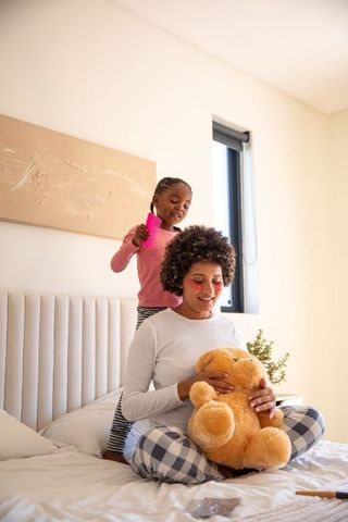 African American Mother and Daughter Bonding in Cozy Bedroom