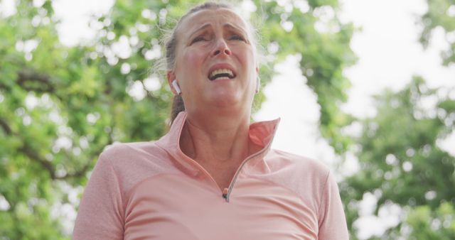 Woman straining during outdoor workout wearing wireless earbuds - Download Free Stock Images Pikwizard.com