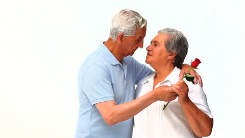 Elderly Couple Embracing with Rose