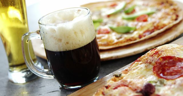 Perfect for promotions or advertisements for bars, pubs, or restaurants. Highlights enjoyment of cold drinks and freshly made pizza in a casual dining environment. Can be used in articles, blogs, or social media posts focusing on food and drink pairings or casual dining experiences.