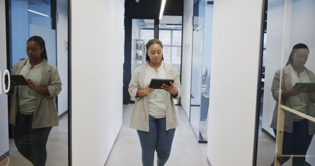 Professional Woman Walking in Narrow Office Corridor, Working on Tablet - Download Free Stock Images Pikwizard.com