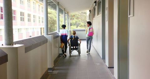 Inclusive Education: Students Supporting Friend in Wheelchair - Download Free Stock Images Pikwizard.com