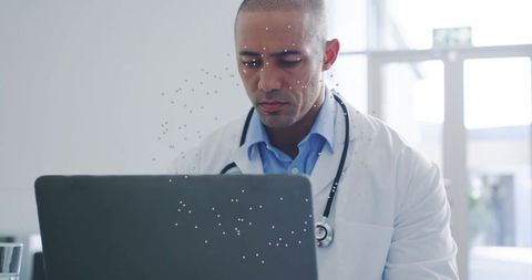 Focused Hispanic Doctor Typing Records at Modern Clinic Reception
