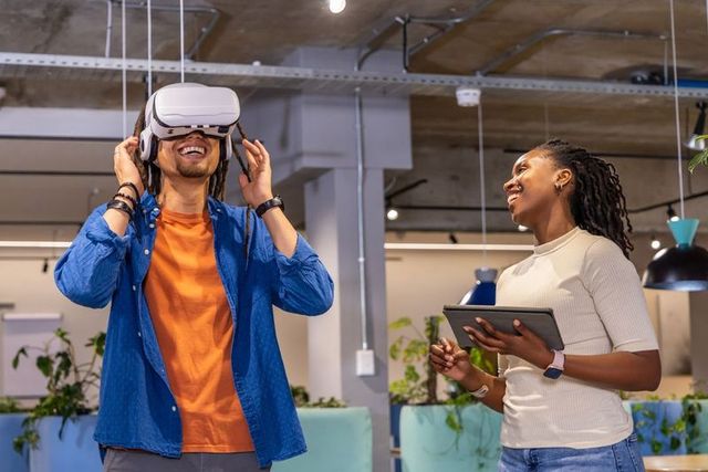 Diverse team testing vr headset in modern open-plan office for collaboration and innovation
