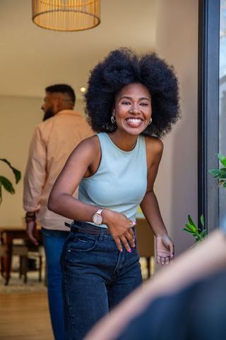 Joyful Young Woman Entering Stylish Modern Home with Warm Decor
