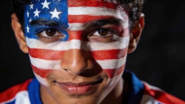 Close-up teen smiling with american flag face paint wearing sports jersey patriotic themes