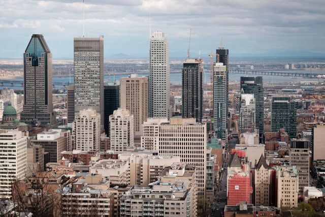 Captivating view of the Montreal skyline showcasing towering skyscrapers and diverse city architecture. Ideal for use in travel blogs, city guides, real estate advertisements, or urban living articles highlighting Montreal's dynamic metropolitan area.