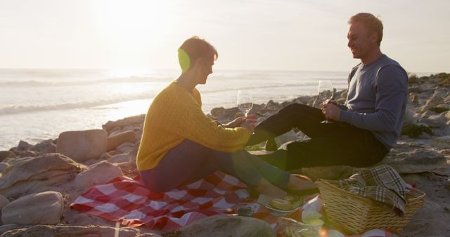 Couple Enjoying Picnic on Rocky Beach During Sunset - Download Free Stock Images Pikwizard.com