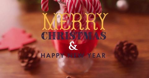 Cozy rustic candy canes in glass jar with red ribbon and pinecones holiday bokeh