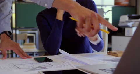 Team Collaboration on Architectural Plans in Modern Office Setting