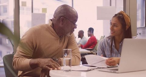 Senior Man and Hispanic Woman Collaborating in Modern Office