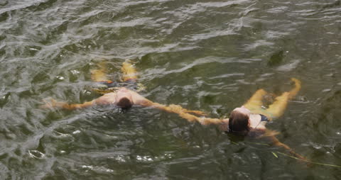 Couple Relaxing in Mountain Lake Floating on Back