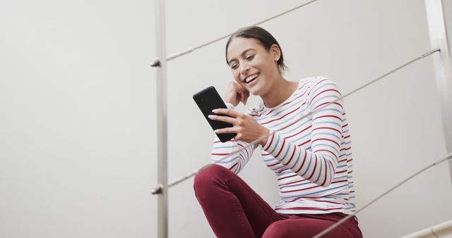 Laughing Woman Using Smartphone in Casual Setting - Download Free Stock Images Pikwizard.com