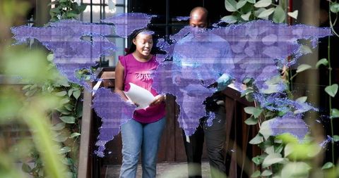 Walking colleagues mentoring, reviewing documents on campus bridge with purple hologram