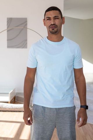 Man Checking Smartwatch Near Abstract Art in Modern Home