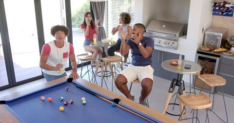 Diverse Friends Gathering for Fun Pool Game and Socializing