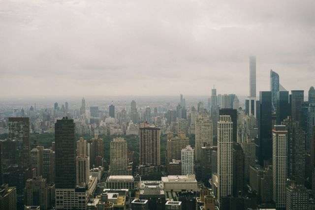Depicts New York City's skyline on a foggy morning with skyscrapers and urban buildings. Useful for illustrating articles about urban living, travel experiences, metropolitan studies, or the architecture and design of high-rise buildings in major cities. Can be used in travel brochures, architecture analyses, or blog posts about New York City.