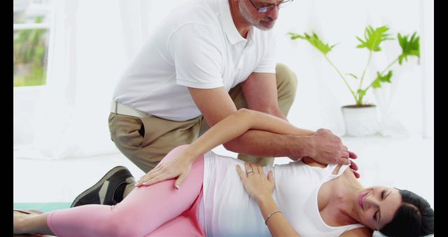 Healthcare professional assisting patient with physiotherapy exercises indoors, highlighting rehabilitation and recovery. Useful for articles on physical therapy, rehabilitation centers, healthcare services, and wellness programs.