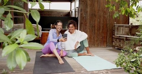 Diverse Women Sharing Relaxed Time on Yoga Mats in Nature