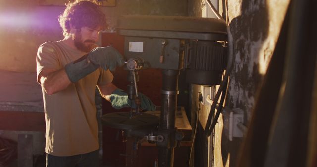 Caucasian male blacksmith forging metal tool in workshop. small business and craftsmanship at a blacksmiths forge.