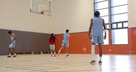 Basketball Team Training with Coach on Indoor Court