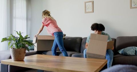 Young Couple Unpacking Boxes in Living Room of New Home