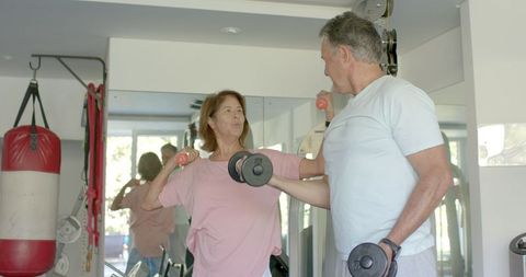 Senior Couple Enjoying Home Gym Workout with Dumbbells