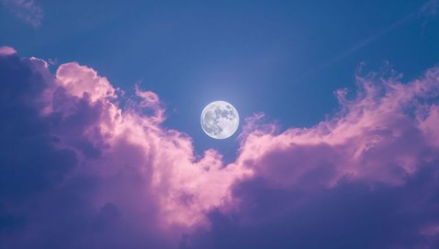Full Moon Glowing with Pink-Hued Clouds in Atmospheric Dusk Sky